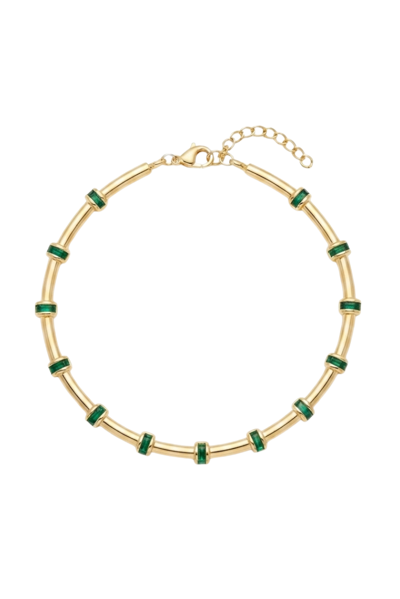 a gold bracelet with green stones