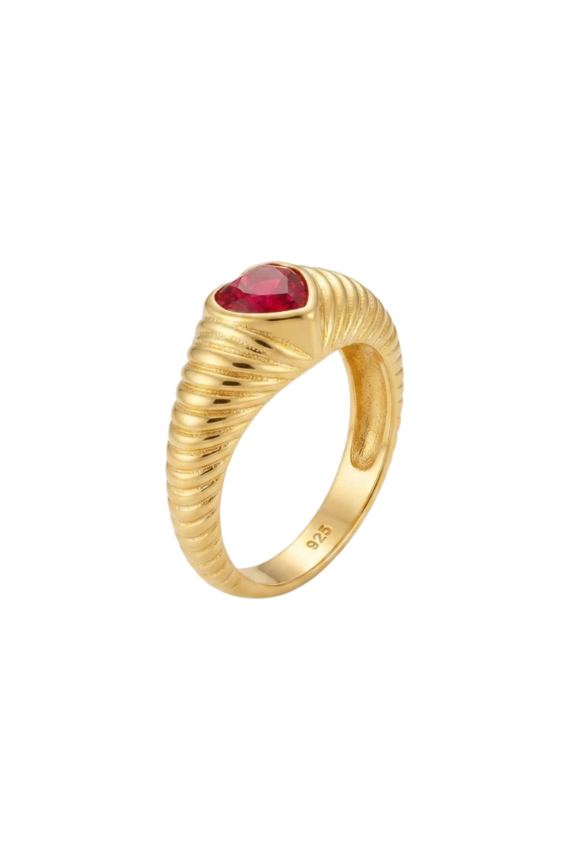 a gold ring with a red stone