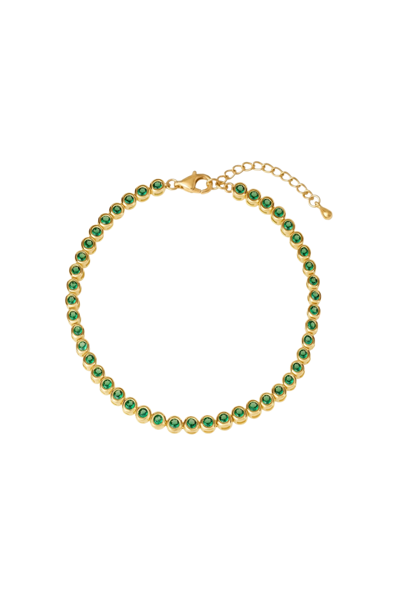 a gold bracelet with green stones